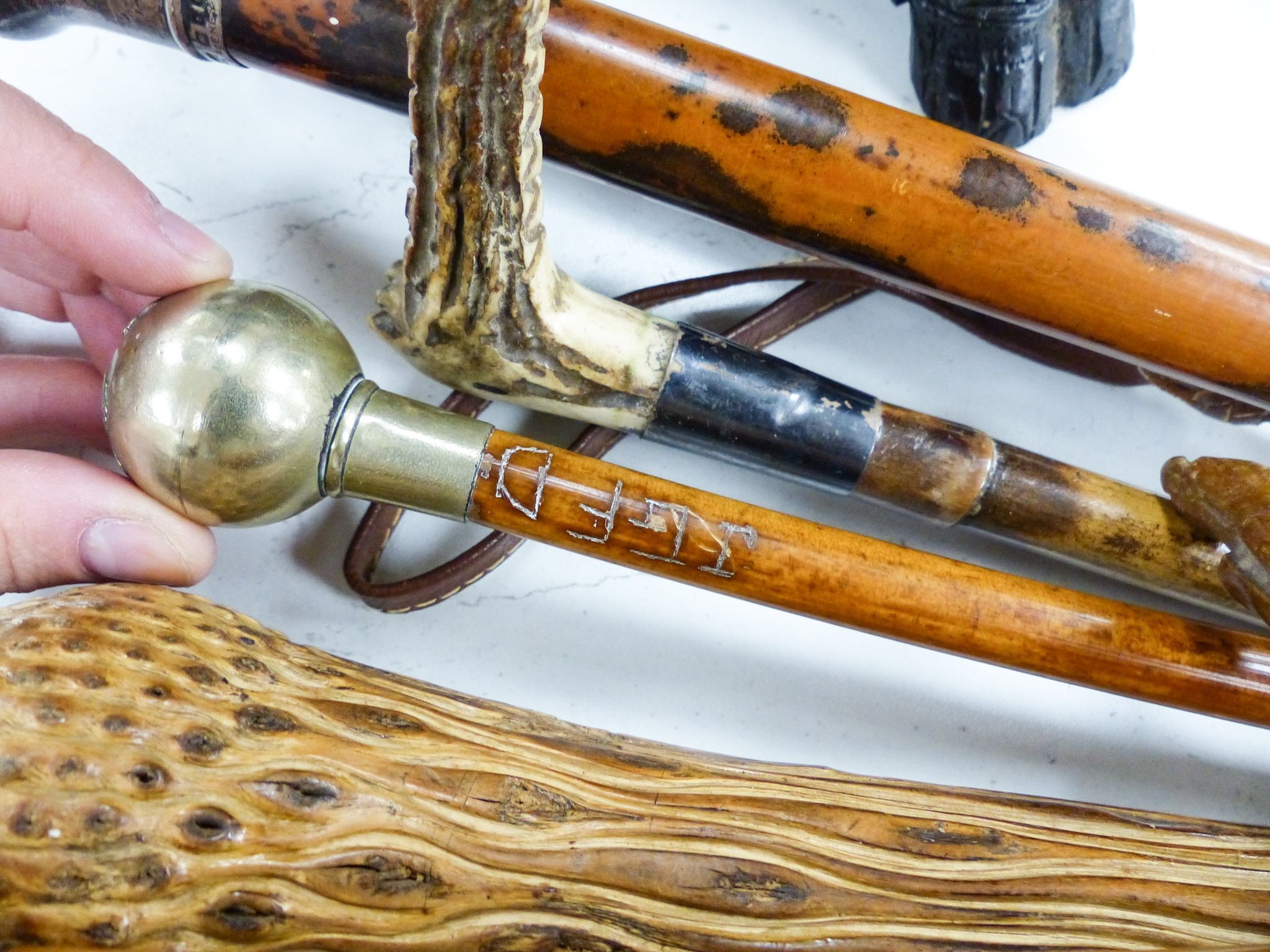 Three silver mounted canes, carved crops and tipstaffs